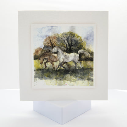 watercolour painting of two horses galloping in a field