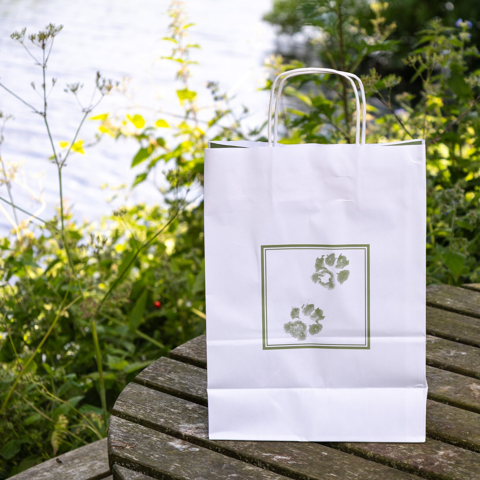 White regular pet casket bag by Sarah Brown Cards on table with River Waveney in the background 