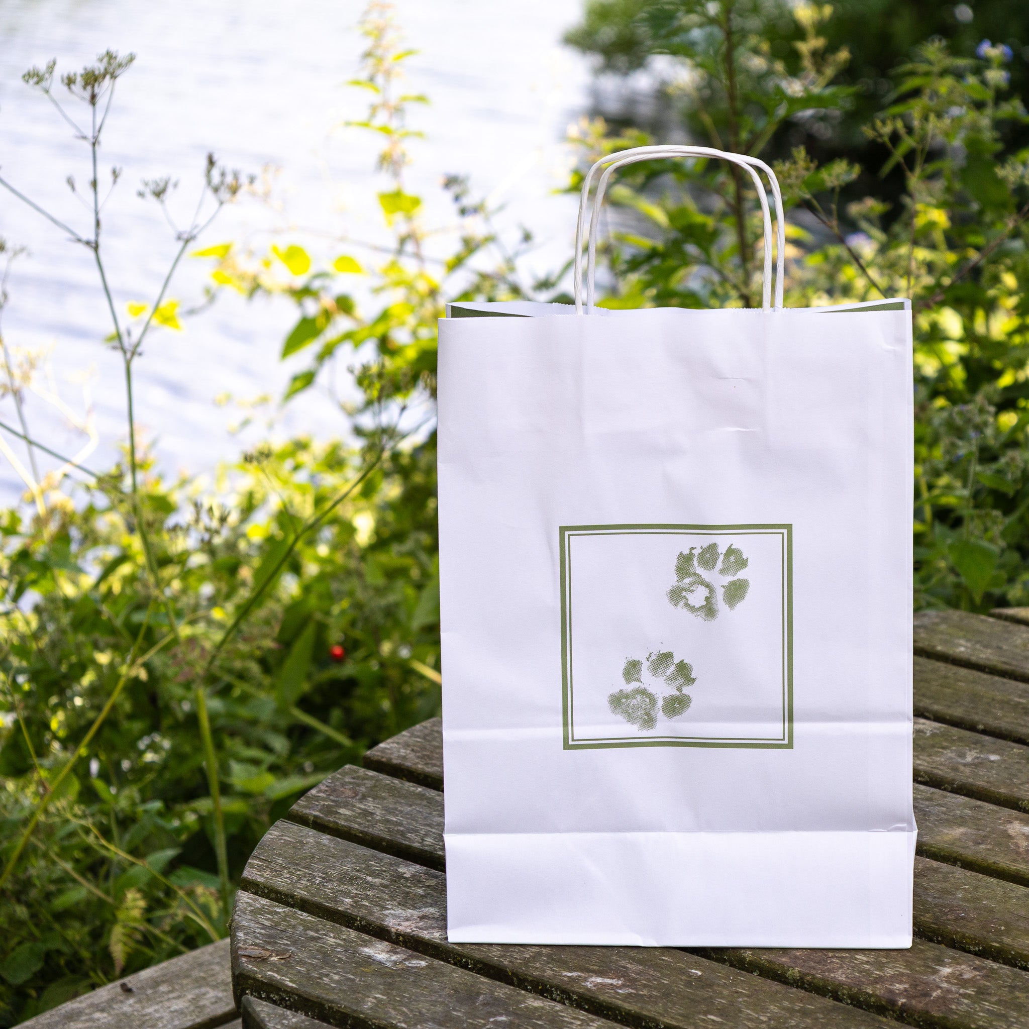 White regular pet casket bag by Sarah Brown Cards on table with River Waveney in the background 